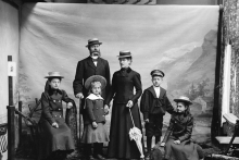 Folk i finstasen gjør seg klare til fotografering hos en fotografs atelier i 1906.