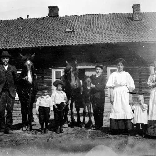 Bilde av mennesker foran hus